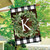 Briarwood Lane Wreath Monogram K double-sided house flag with greenery on plaid background outdoor decor.
