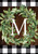 Briarwood Lane monogrammed wreath with greenery and checkered border on a wooden background.