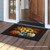 Briarwood Lane Patterned Pumpkins and Sunflowers doormat on a wooden porch outside an open door.