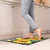 Briarwood Lane Checkered Sunflowers Comfort Mat with yellow sunflowers and green leaves on black background.
