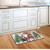 Briarwood Lane Wagon Gnome Doormat on a wooden floor in front of kitchen sink area.