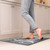 Briarwood Lane Home Sweet Home Comfort Mat, gray with white design, under a person's bare feet.