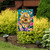 Briarwood Lane Happy Beehive Double-Sided Garden Flag with colorful flowers and bees on display outdoors.