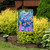 Briarwood Lane Dragonflies Garden Flag with colorful dragonflies and flowers on a garden stand outdoors.