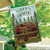 Briarwood Lane Happy Campsite House Flag with wooden cabin and pine trees design hanging outdoors.