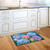 Briarwood Lane Colorful Hydrangeas doormat on wooden floor in front of white kitchen sink cabinets.