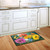 Briarwood Lane Butterflies and Daisies colorful doormat on wooden floor beside kitchen sink and cabinets.