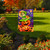 Briarwood Lane Happy Jack-O-Lanterns Garden Flag with colorful Halloween design and purple background outdoors.