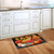 Baskets of Mums doormat on kitchen floor with white cabinets and wooden floorboards nearby sink.