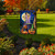 Witches Brew Garden Flag with Halloween design featuring pumpkins, cauldron, and witch in a garden.