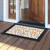Citrus and Vines doormat with orange, black, and white design on a wooden porch floor.