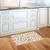 Citrus and Vines doormat on wooden floor with white cabinets and orange, black, and white design.