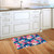 Vibrant floral doormat with pink, blue, and white flowers on a navy background in a kitchen.