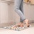 Citrus and Vines comfort mat with vibrant orange, blue, and white pattern on kitchen floor.