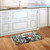 Winter Woodland Birds Doormat on wooden floor in front of white kitchen sink cabinets.