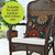 Orange and Teal Floral Burlap Pillow on a wicker chair with white cushion, outdoor decor.