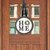Wooden Home Door Hanger with black plaid border and green wreath on white background hanging on door.