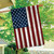 Wood American Flag House Flag with wooden texture and stars on blue background hanging outdoors.