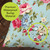 Spring Floral Burlap Pillow, water droplets on blue floral burlap fabric with pink, red, and white flowers.