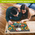 Couple working on Briarwood Lane Colorful Pumpkin Stack 1000 Piece Jigsaw Puzzle on wooden floor.