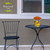 Small black metal table and chair with Briarwood Lane Checkered Sunflowers Decorative Planter on top.