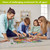 Family assembling Bunnies and Basket Easter 1000 Piece Jigsaw Puzzle on living room floor together.