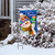 Let It Snow Snowman Garden Flag with colorful snowman design on blue background with snowflakes outside.