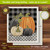 Checkered pumpkins fall decorative Swedish dishcloth with black, orange, and white pumpkins on plaid background.