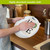 Home Swedish Dishcloth drying plate with herbs on white reusable cloth in kitchen setting.