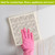 Distressed Tiles Swedish Dishcloth, pink glove hand holding decorative cleaning cloth on white surface.
