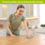 Woman using Woodcut Floral Swedish Dishcloth on a wooden table in a modern kitchen setting.