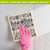 Woodcut Floral Swedish Dishcloth, hand in pink glove holding black and white floral dishcloth.