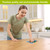 Woman using Colorful Birdhouses Swedish Dishcloth on a kitchen counter, made eco-friendly materials.