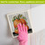 Country Pumpkins Swedish Dishcloth with orange pumpkins on a gray background, pink glove holding it.