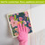Hand in pink glove wiping white surface with Happy Blooms Swedish Dishcloth featuring floral design.