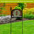 Farmhouse Wreath Acrylic Art Sign with welcome text and greenery on black stand outdoors.