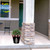 Checkered Trees Medium Planter with green plant on a porch next to a stone pillar outdoors.