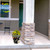 Elegant Flowers Medium Planter with yellow blooms on a porch next to a pillar and chair.