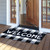 Large black and white checkered coir doormat with welcome text, 30 x 48 inches.