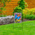 Wrought iron welcome arbor with colorful butterfly garden flag on a stand in green grass area.