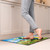 Lucky Irish Gnome Comfort Mat in kitchen with bare feet standing on vibrant colorful design rug.