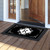 Black and white monogram doormat with decorative border and letter R on wooden porch floor.