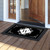 Black and white monogram doormat with decorative border and letter W on wooden porch floor.