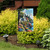 Amazing Grace Garden Flag with serene church and floral design on display outdoors.