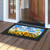 God Bless Our Home doormat with sunflowers and colorful design on wooden porch outside open door.