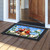 Bless This Home Cardinal Doormat with floral design and black border on wooden porch floor.