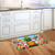 Pineapple and Stripes Doormat with colorful floral design and pineapple on a kitchen floor.