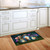 Be a Light Jars colorful doormat on wooden floor beside white kitchen cabinets and sink area.