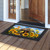 Goldfinches and Sunflowers colorful doormat on wooden porch with black border and vibrant floral design.