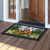 Camping Bear Doormat with colorful camping scene and black border on wooden porch outside doorway.